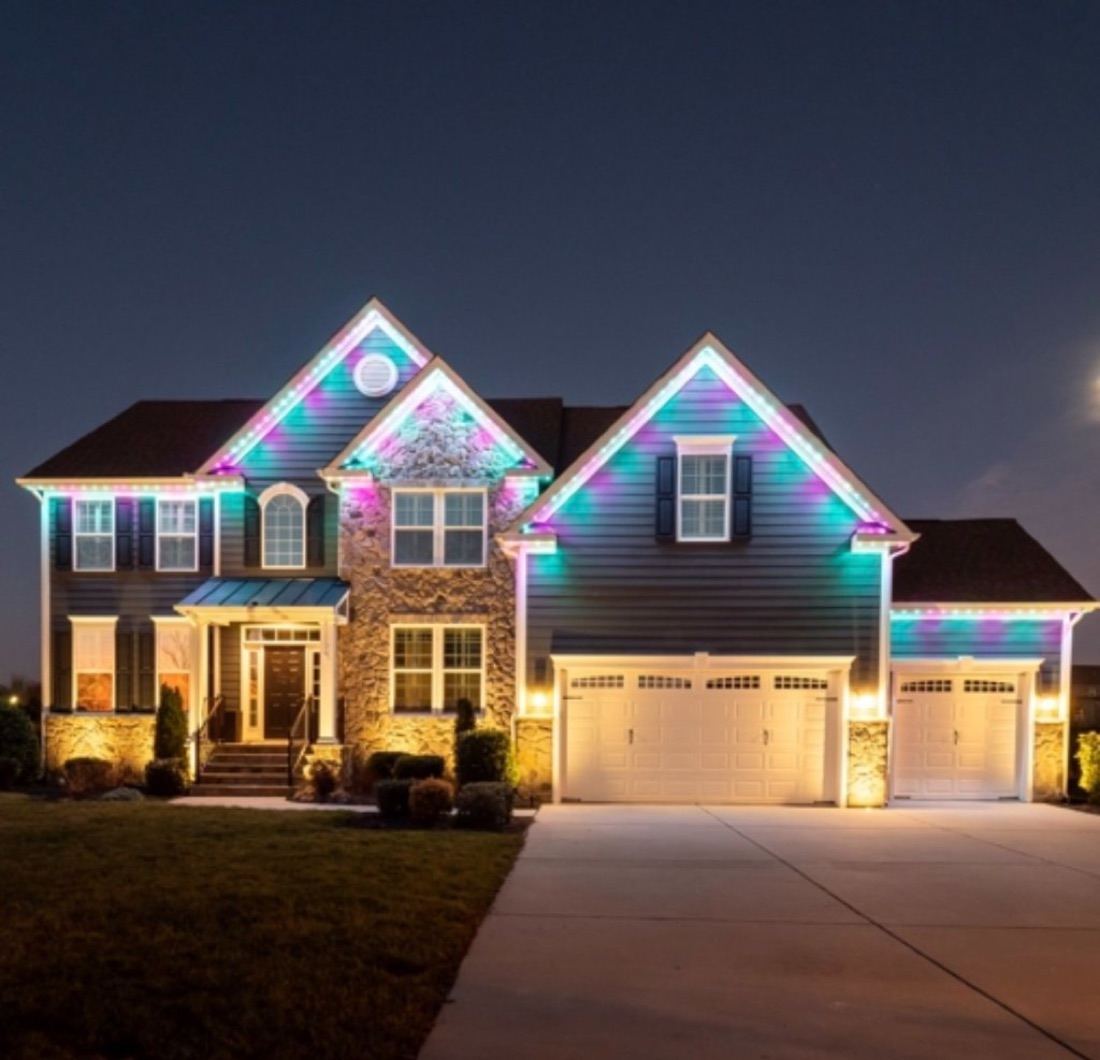 Permanent roofline lighting on a two-story home at night